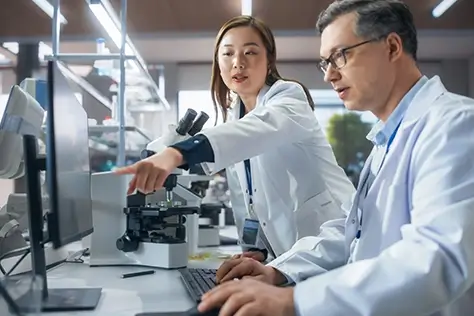 A scientist showing another scientist something on a computer