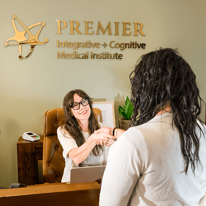 A patient shaking hands with reception at Premier Cognitive
