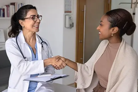 A doctor shaking hands with a patient