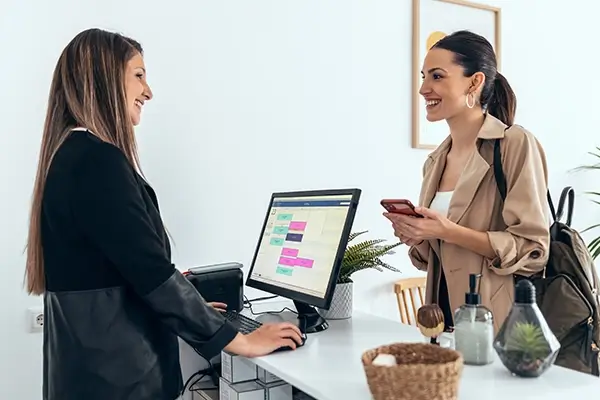 A woman checking in for an appointment at the front desk