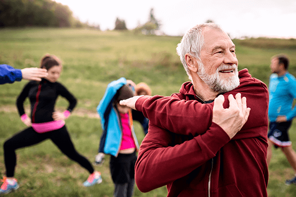 A man stretching in front of an active group outdoors
